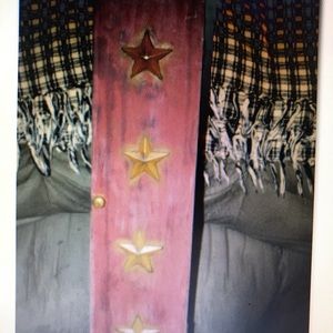 Burgundy toilet paper holder with mustard yellow stars.